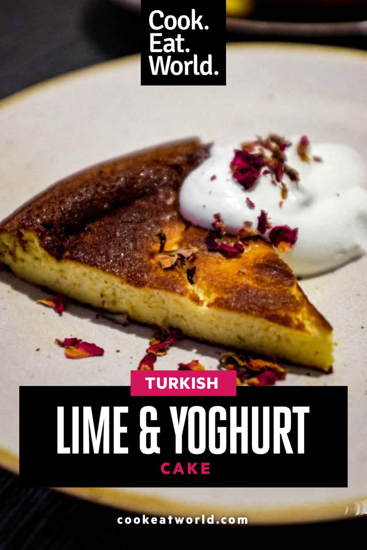 Turkish Lime Yoghurt Cake on a plate with cream, scattered with rose petals.