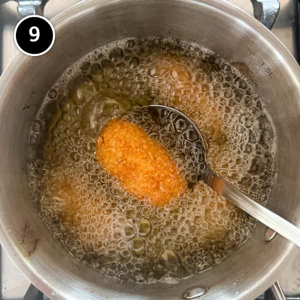 A croqueta being deep fried in oil