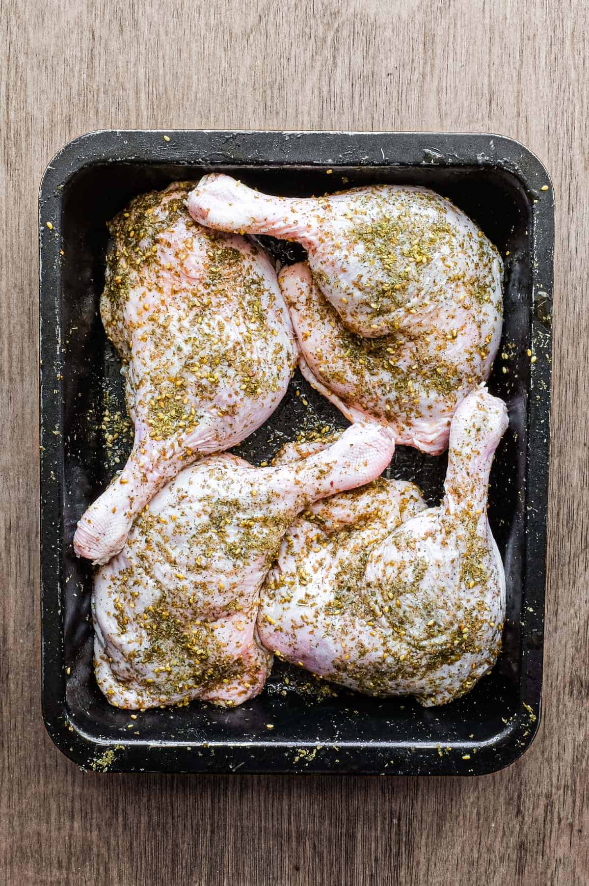 4 raw duck legs, scattered with zaatar in a baking tin