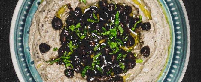 A bowl of black hummus made with black chickpeas