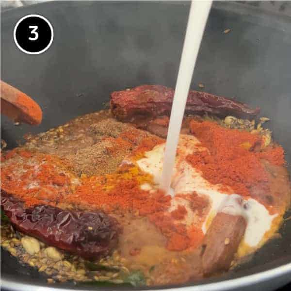 Ground spices and coconut milk forming a curry paste in a pan