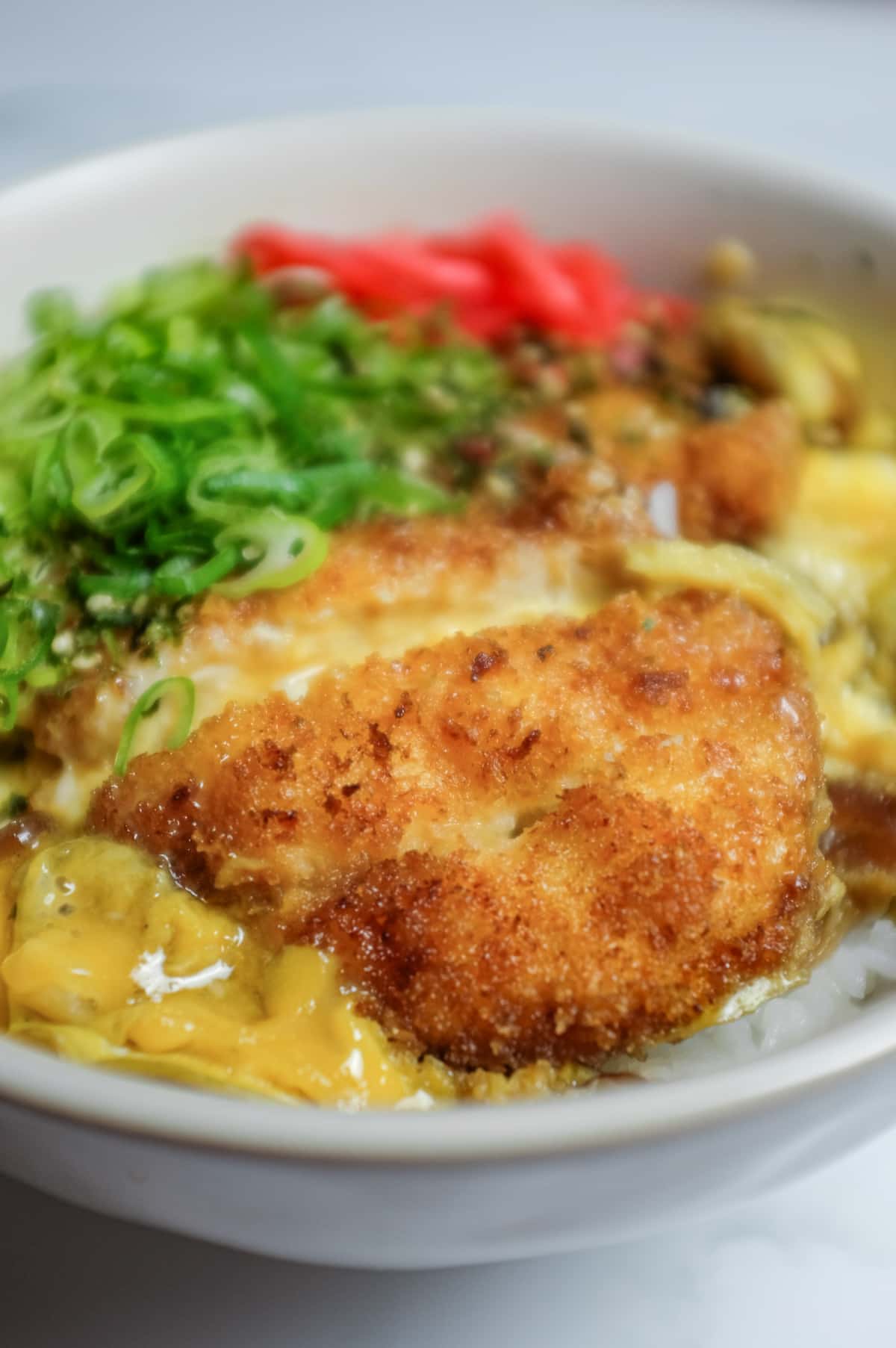 Overhead view of chicken katsudon with egg-draped katsu and short-grain rice