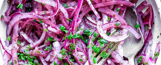 A small bowl of Sumac Onions with a small serving fork and spoon