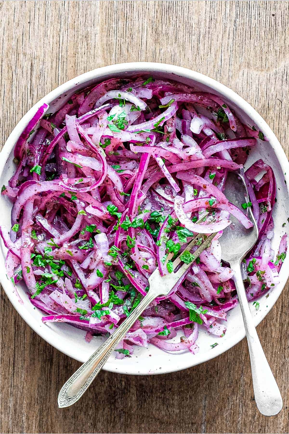 A small bowl of Sumac Onions with a small serving fork and spoon