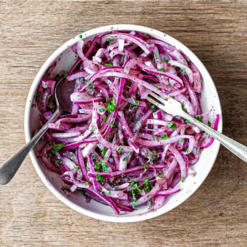 A small bowl of Sumac Onions with a small serving fork and spoon
