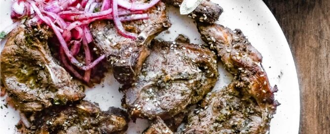 A platter of Zaatar Lamb chops with a side serving of Sumac Onion Salad