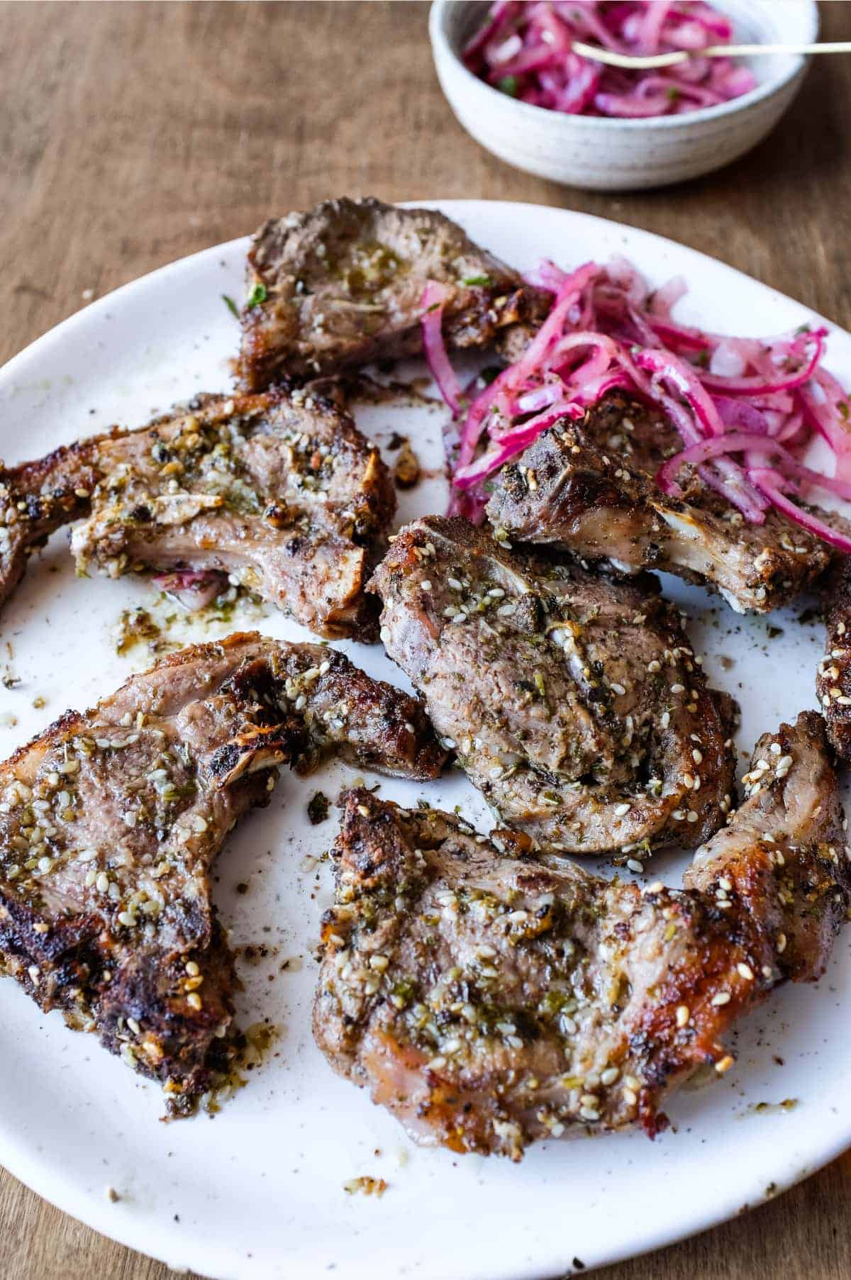 A platter of Zaatar Lamb chops with a side serving of Sumac Onion Salad