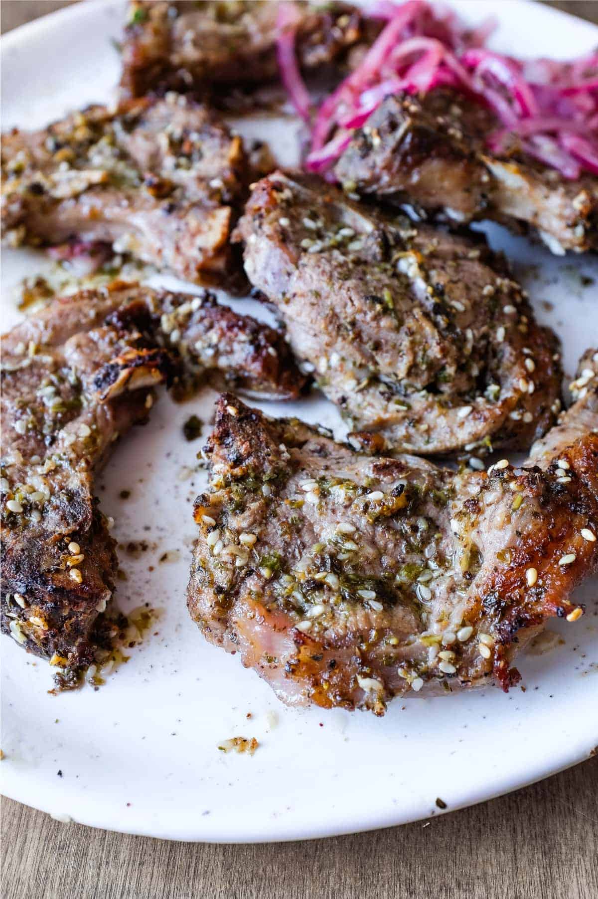 A platter of Zaatar Lamb chops with a side serving of Sumac Onion Salad