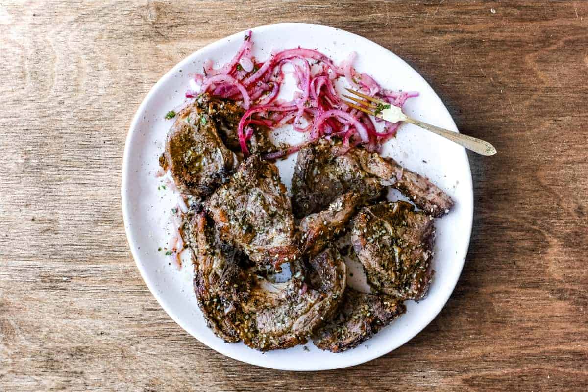 A platter of Zaatar Lamb chops with a side serving of Sumac Onion Salad
