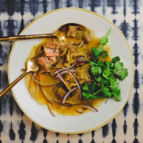 A platter of Filipino pork adobo, garnished with fresh cilantro