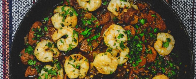 A platter of chorizo and prawns cooked in Fino Sherry. Bowls of lemon wedges and bread sit alongside.