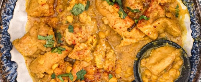 A plate of Pakistani Chicken Lahori curry with a black serving spoon