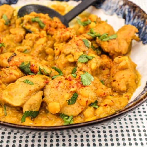 A plate of Pakistani Chicken Lahori curry with a black serving spoon