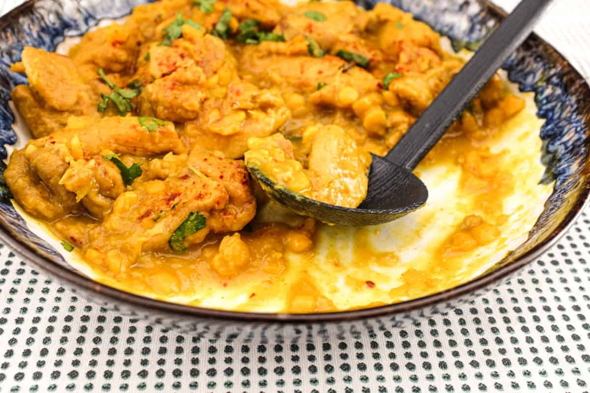 A plate of Pakistani Chicken Lahori curry with a black serving spoon