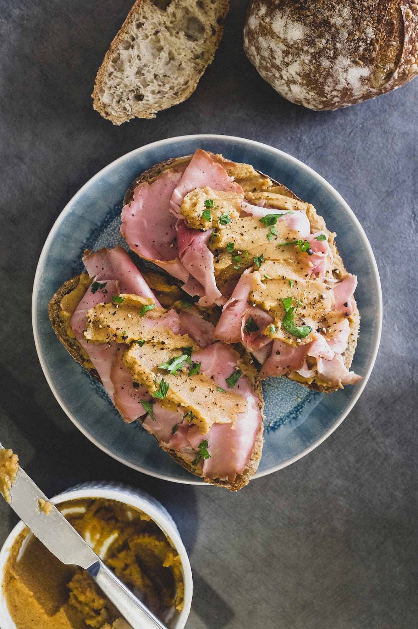 A an open sandwich with ham and pease pudding.