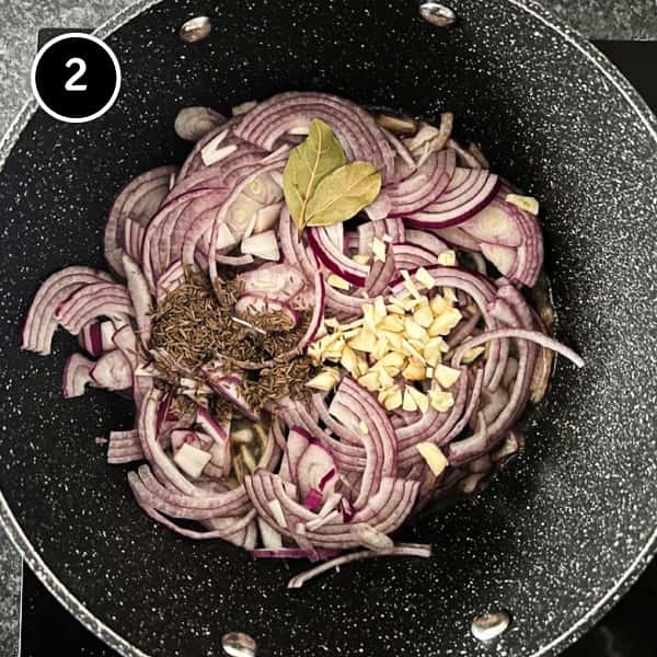 Onion, garlic, bay leaves and caraway frying in a large pot