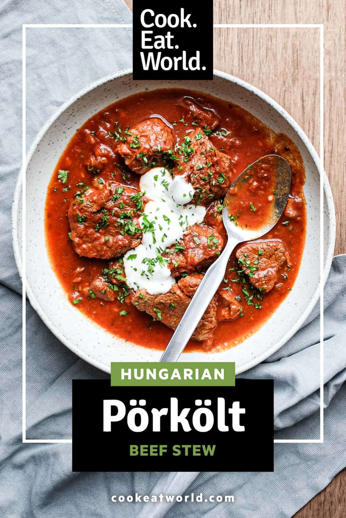 A bowl of Hungarian Pörkölt Beef Stew in a bowl, wrapped in a tea towel.