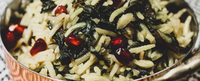 A small copper pot holds some Moroccan rice with Silverbeet, garnished with pomegranate seeds
