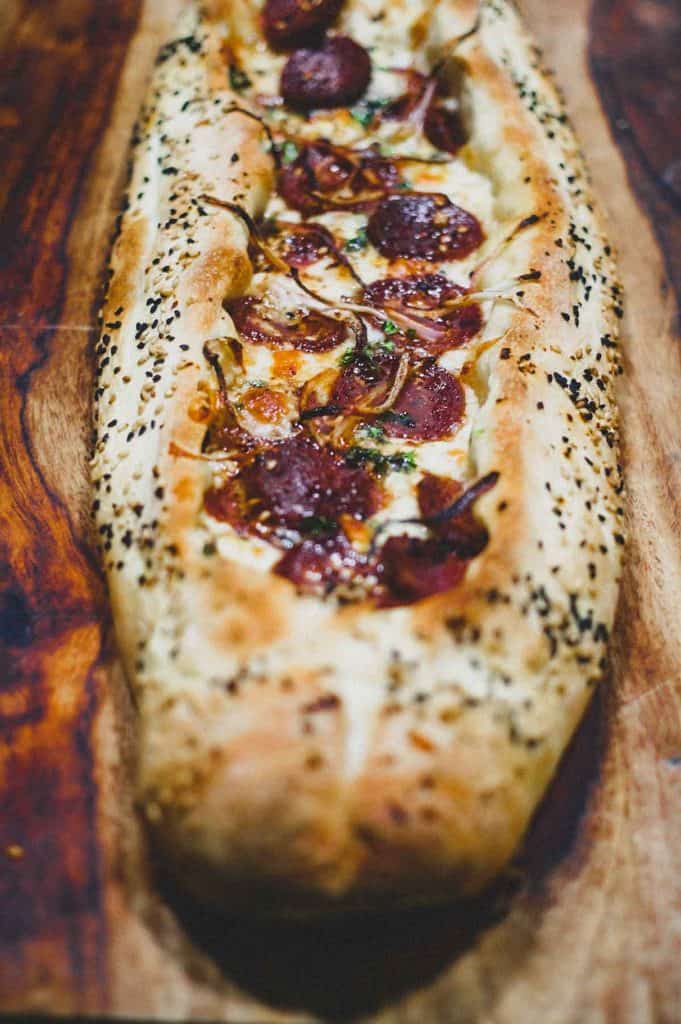 A whole Turkish Sucuk Pide on a wooden board