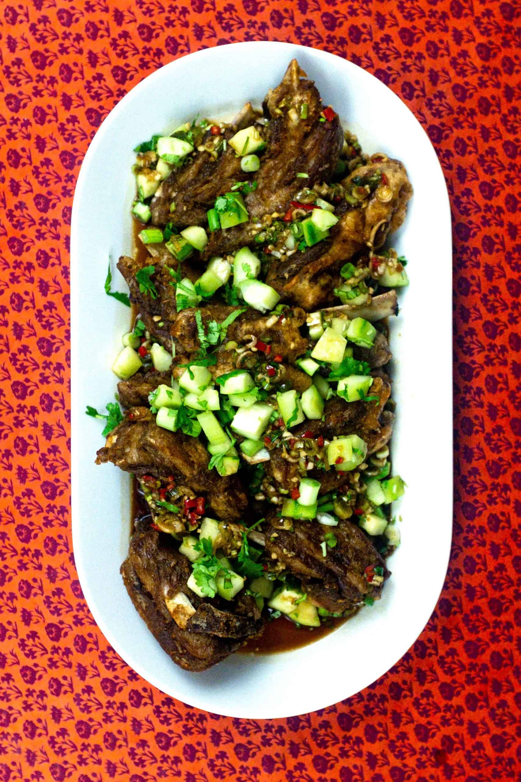 Shantung Lamb Ribs on a large platter on a red patterned background