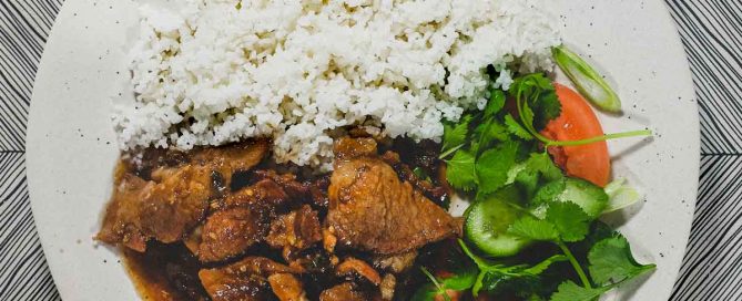 Vietnamese Pork with Lemongrass & Chilli on a plate with boiled broken rice and a salad