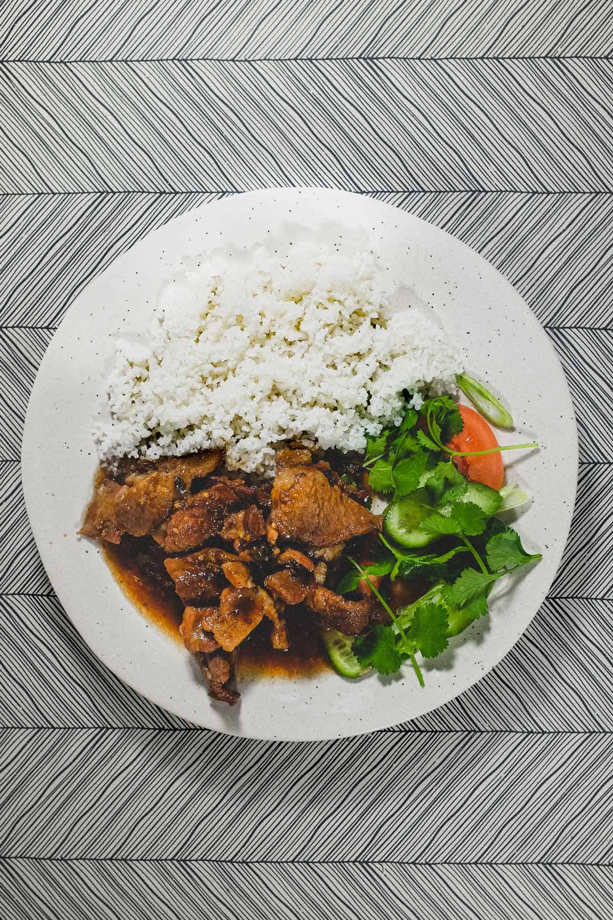 Vietnamese Pork with Lemongrass & Chilli on a plate with boiled broken rice and a salad