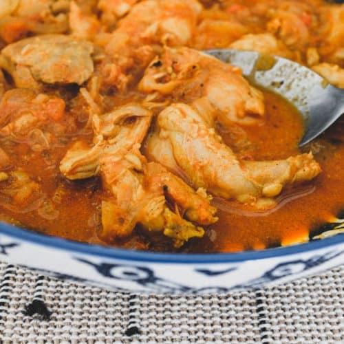 Chicken cooked with vinegar. spices, garlic and tomato.