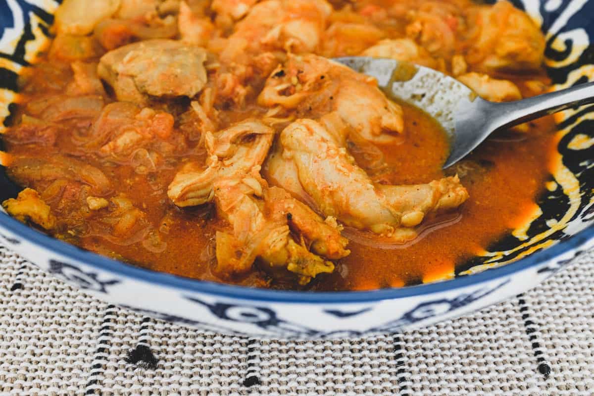 Chicken cooked with vinegar. spices, garlic and tomato.