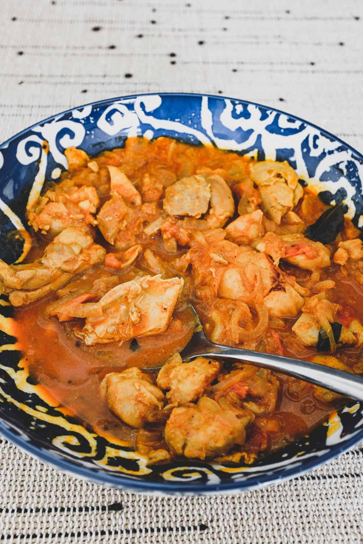 Chicken cooked with vinegar. spices, garlic and tomato.