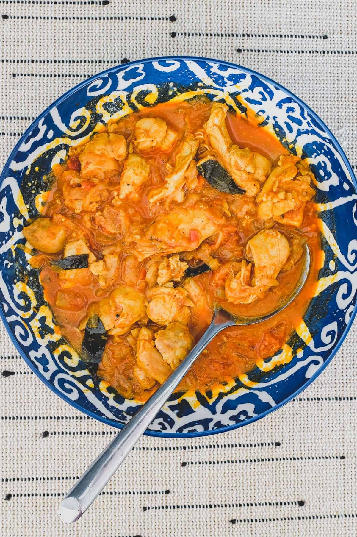 Chicken cooked with vinegar. spices, garlic and tomato.