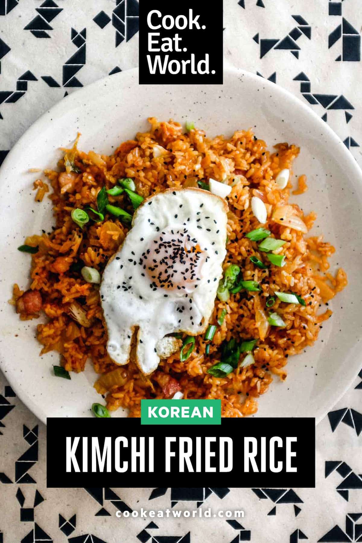 A plate of kimchi fried rice with a crisp fried egg on top scattered with spring onions