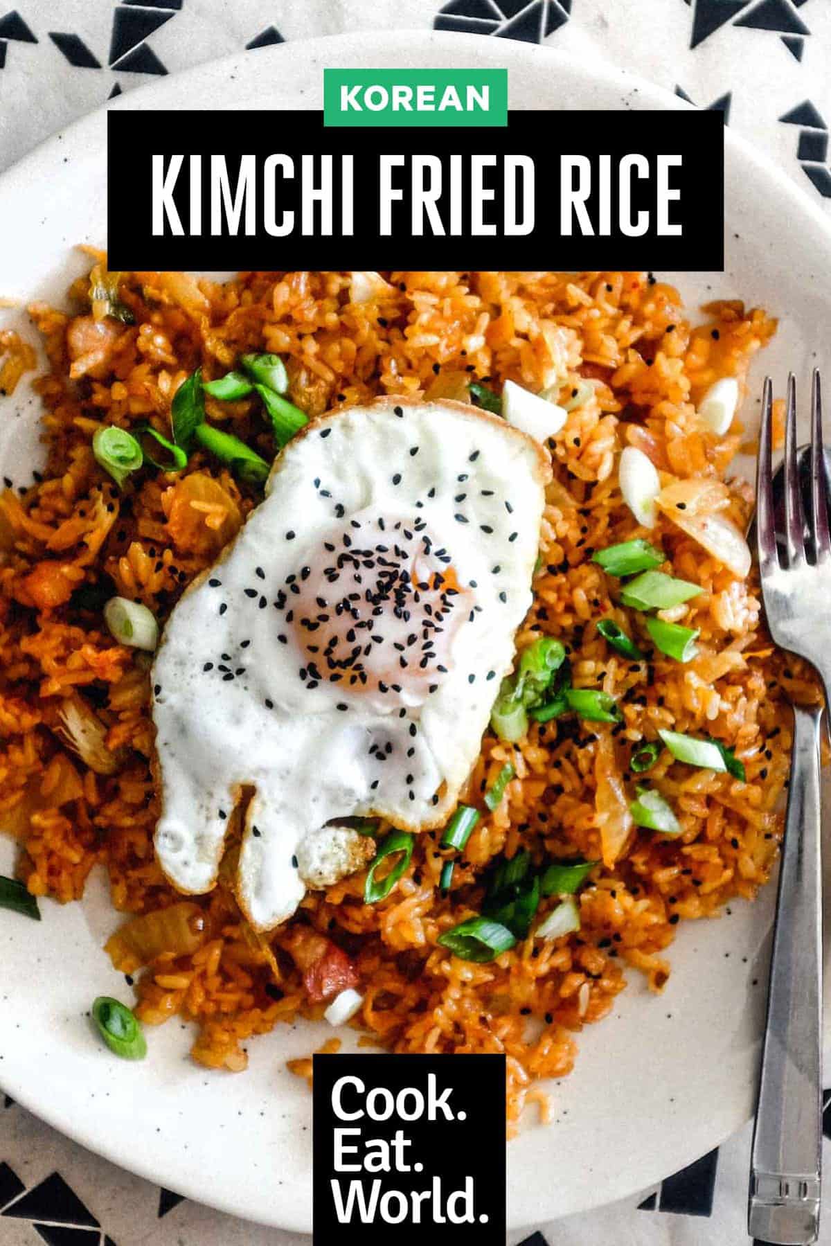 A plate of kimchi fried rice with a crisp fried egg on top scattered with spring onions