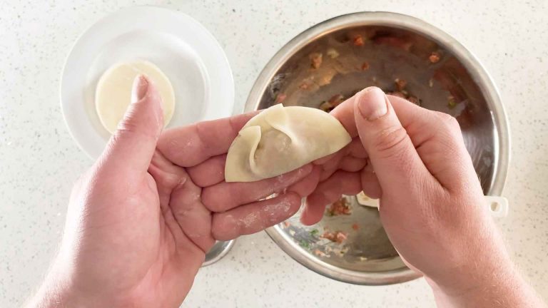 Make sure the dumpling is well sealed as close to the filling as you can, this will ensure they don't burst while cooking.
