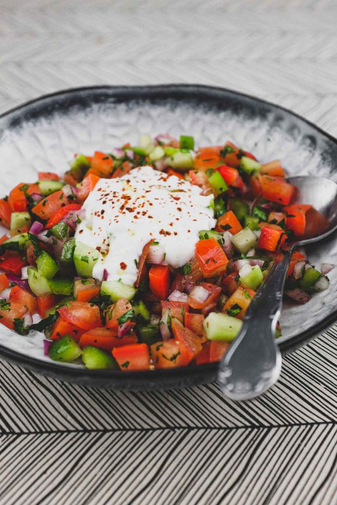 A bowl of turkish salad with a yoghurt dressing
