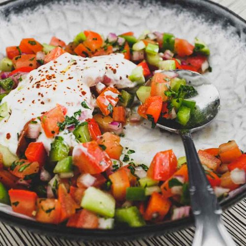 A bowl of turkish salad with a yoghurt dressing