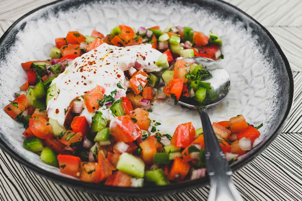 A bowl of turkish salad with a yoghurt dressing