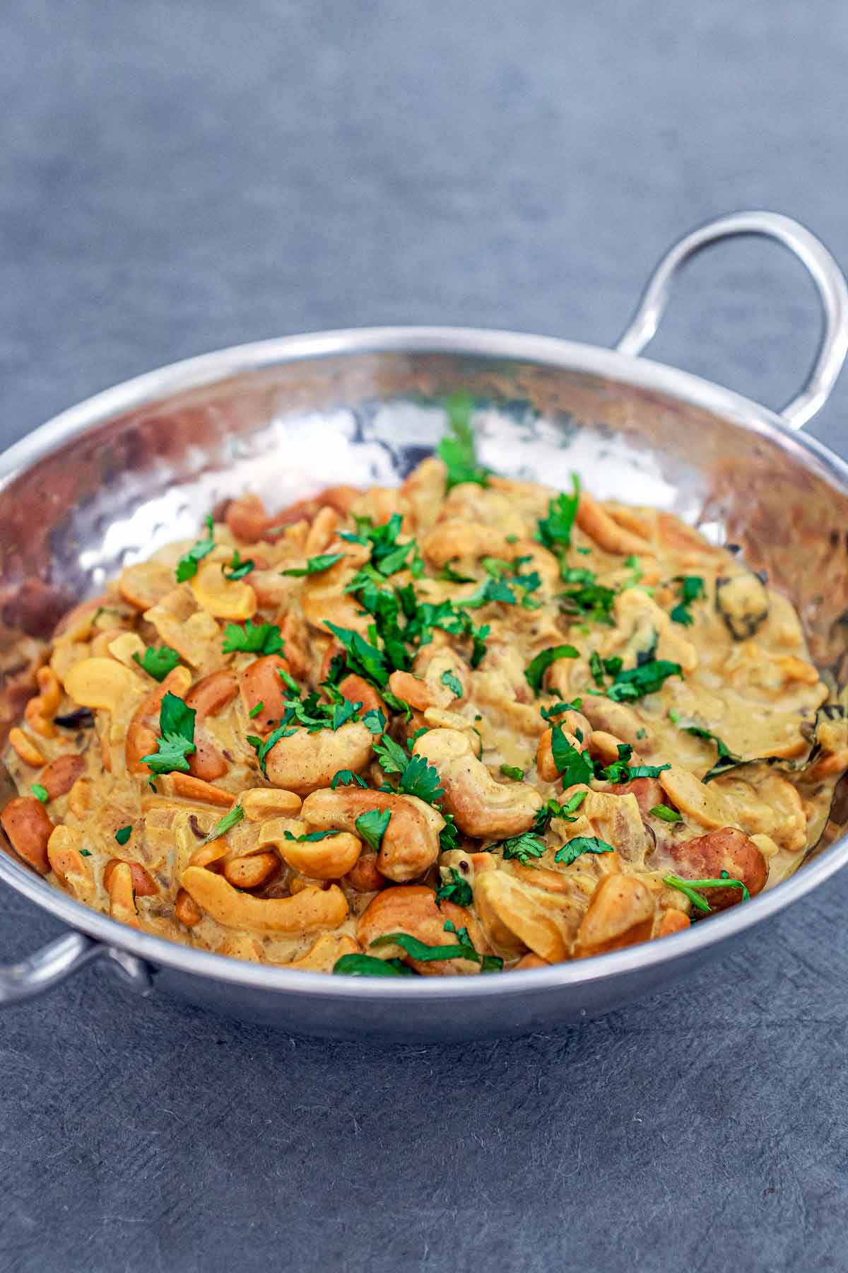 A silver bowl of cashew nut curry