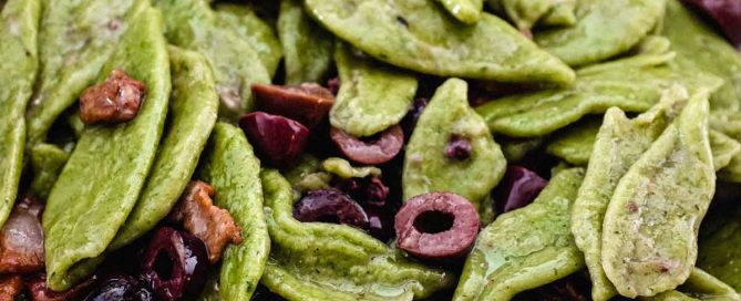 A bowl of foglie d'ulivo pasta with pancetta and black olives