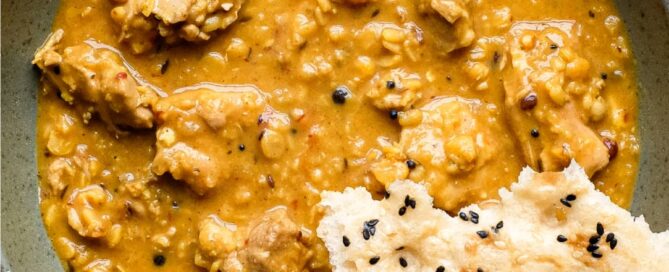 A bowl of lentil curry with a piece of naan bread
