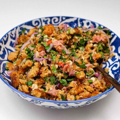 A bowl of Laotian Nam Khao crispy rice salad