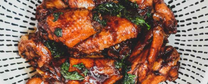 Homemade Three Cup Chicken in bowl with glossy sauce and fresh basil