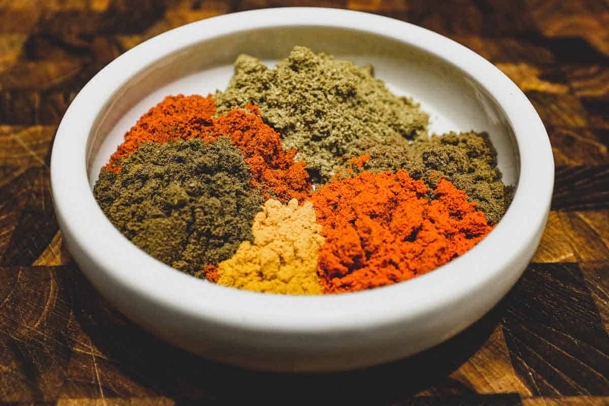 A bowl of ground spices. Cumin, paprika, coriander, turmeric, garam masala and cayenne pepper