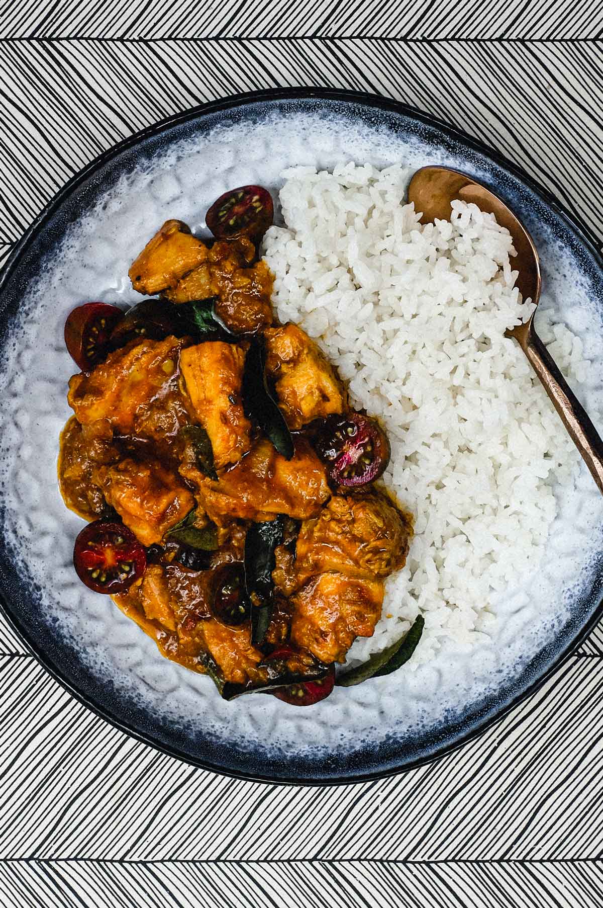 A bowl of chicken chukka curry with rice.