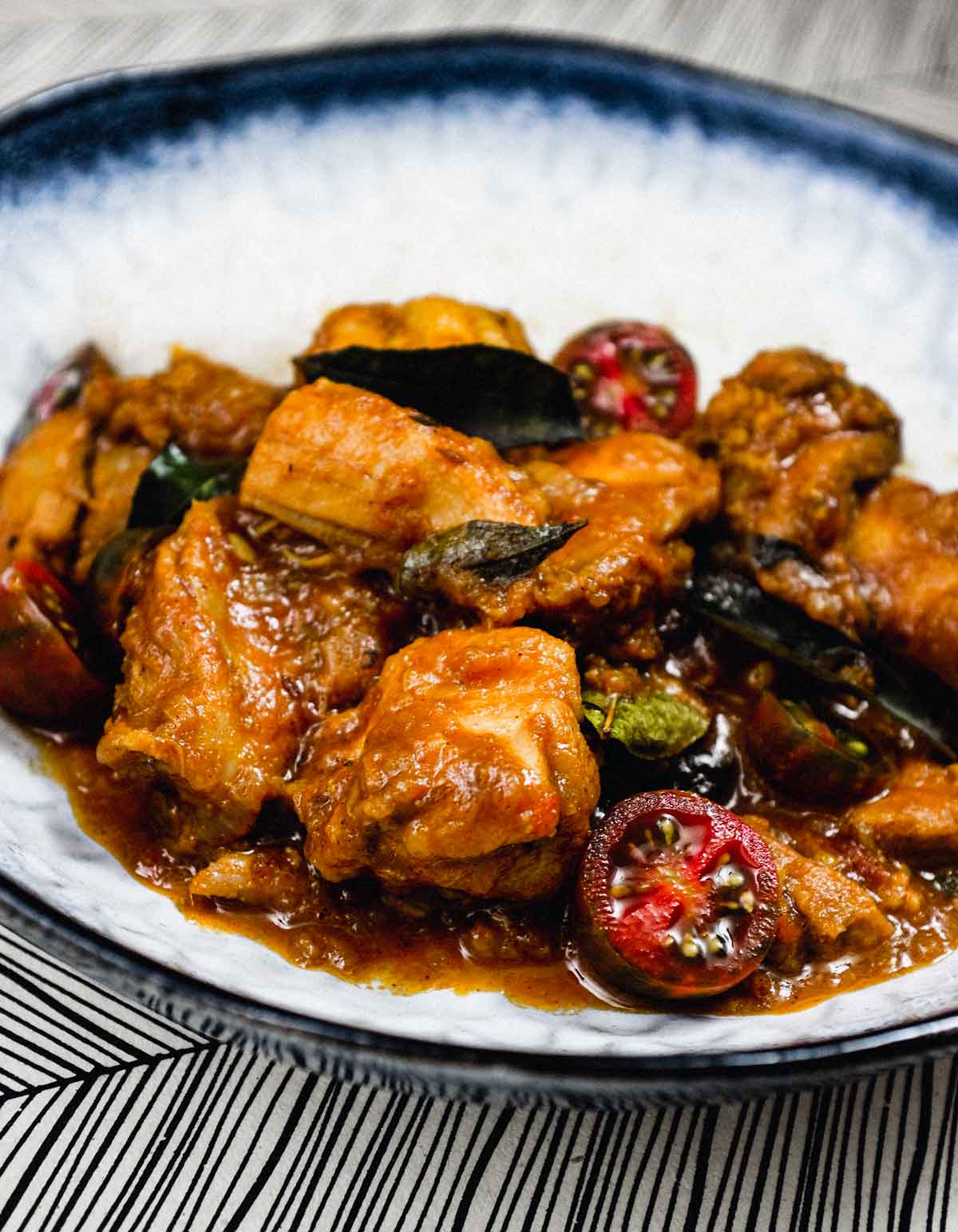 A bowl of chicken chukka curry with rice.