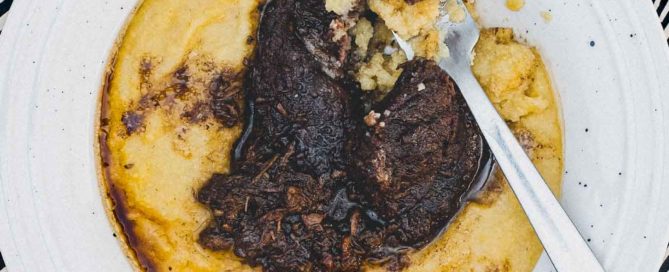 A bowl of Creamy Polenta with Peposo Alla Fornacina (Tuscan Beef Stew)
