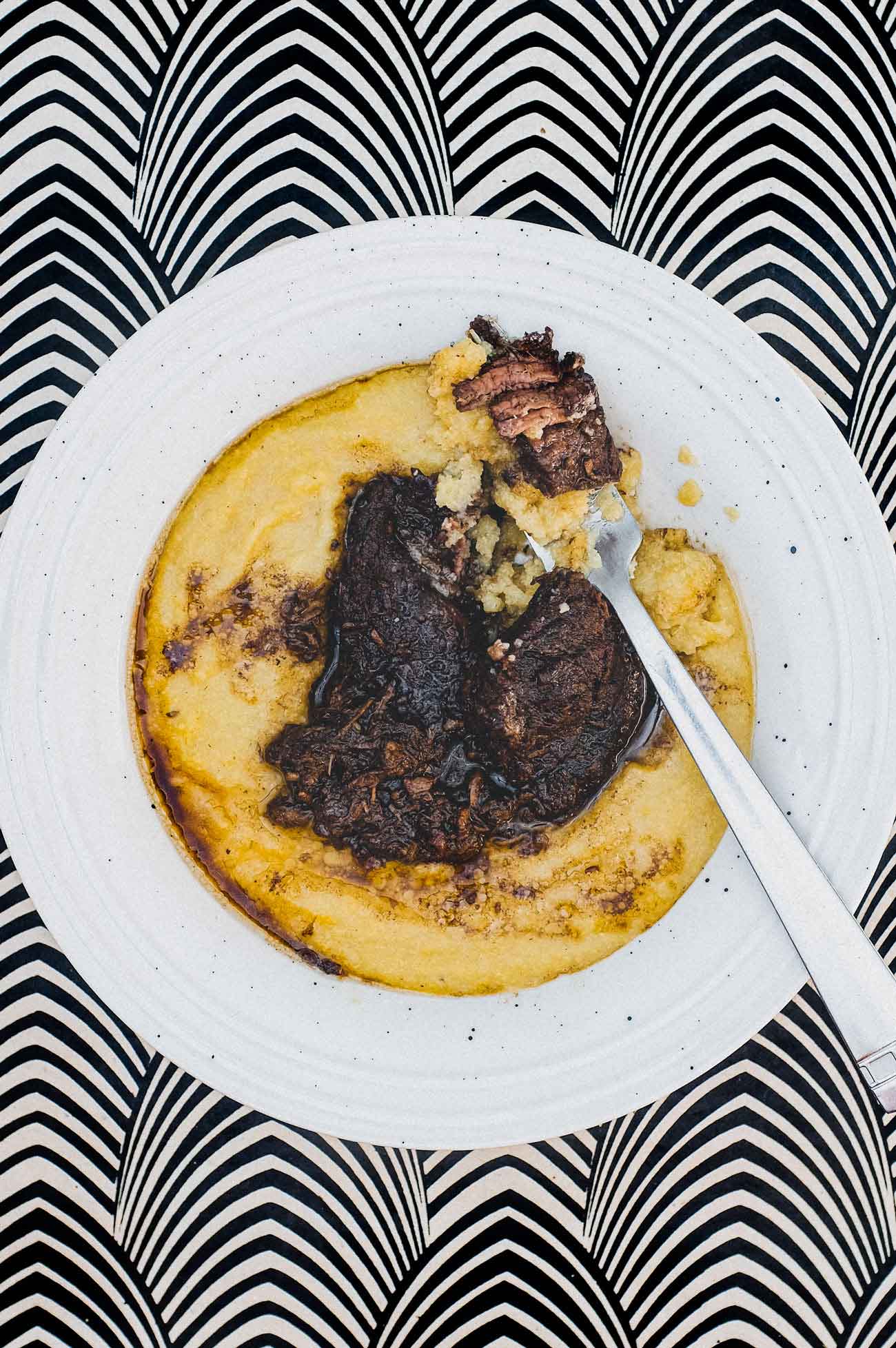 A bowl of Creamy Polenta with Peposo Alla Fornacina (Tuscan Beef Stew)