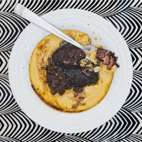 A bowl of Creamy Polenta with Peposo Alla Fornacina (Tuscan Beef Stew)