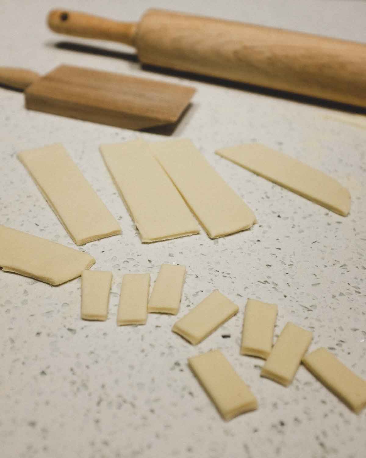 cutting fresh pasta into small pieces, ready for rolling into cavatelli shapes.