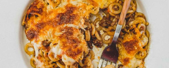 Anelletti Al Forno - baked rings of pasta in a tomato sauce in a bowl with a fork