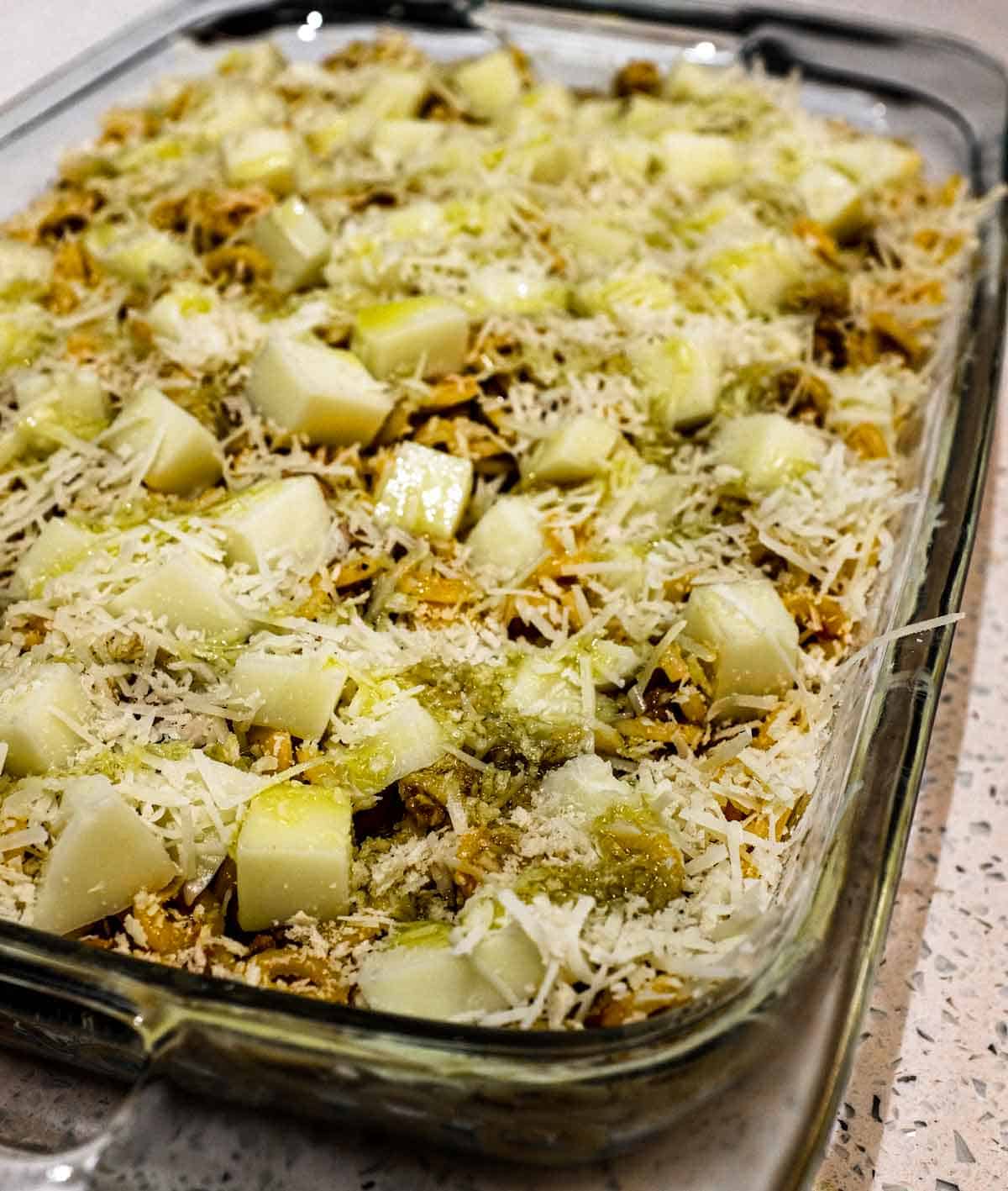 A baking dish of anelletti al forno about to go into the oven. Topped with cubes of mozzarella cheese.